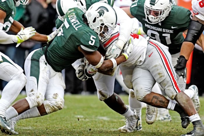 Michigan State's Andrew Dowell, left, tackles Ohio State's Mike Weber Jr. © Nick King/Lansing State Journal